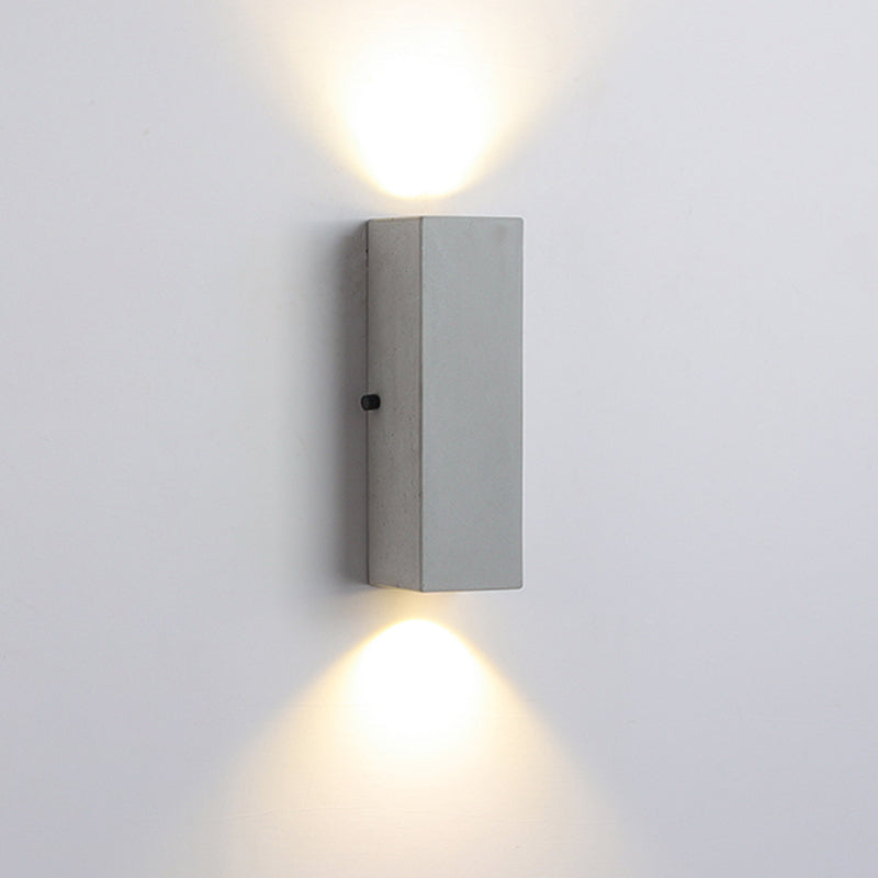 Tall cement wall lamp casting light upward and downward