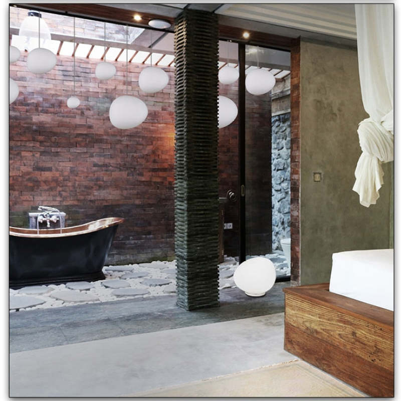 White hanging globes across a brick-and-glass room