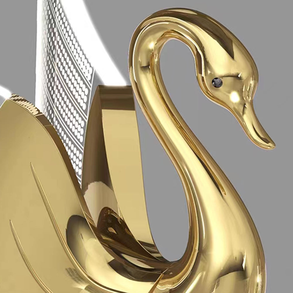 Close-up of the gold swan head with a dark eye-like detail, curved neck and beak beside a patterned wing