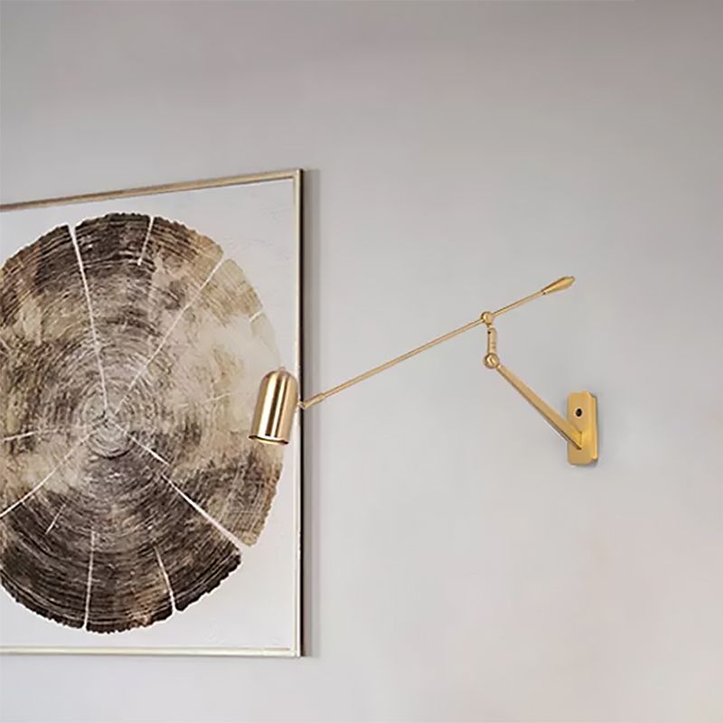 Gold Freja adjustable wall light beside circular wall art.