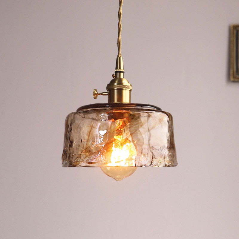 Shallow rounded textured glass pendant with a visible bulb below the open shade