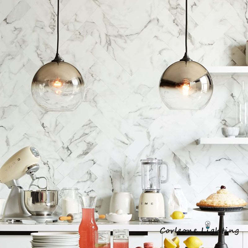 Two gradient globe pendants above a kitchen counter and appliances