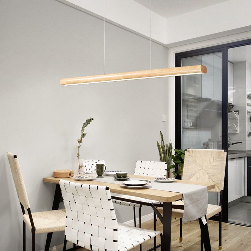 Linear wood-tone pendant above a set dining table