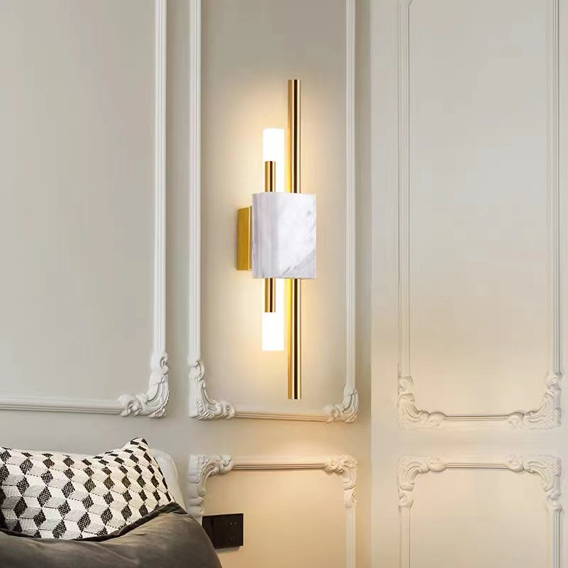 White-veined Alana wall light with gold-tone rods and a lit bar on an ornate pale wall above a sofa