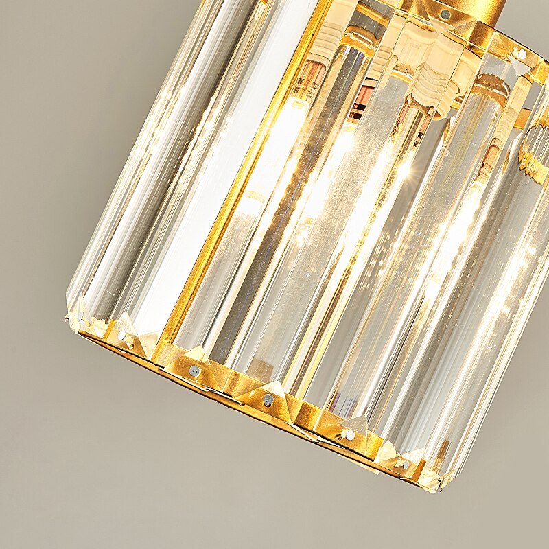 Close view of gold-tone Herbert trim, fixings and vertical faceted glass pieces around a lit source