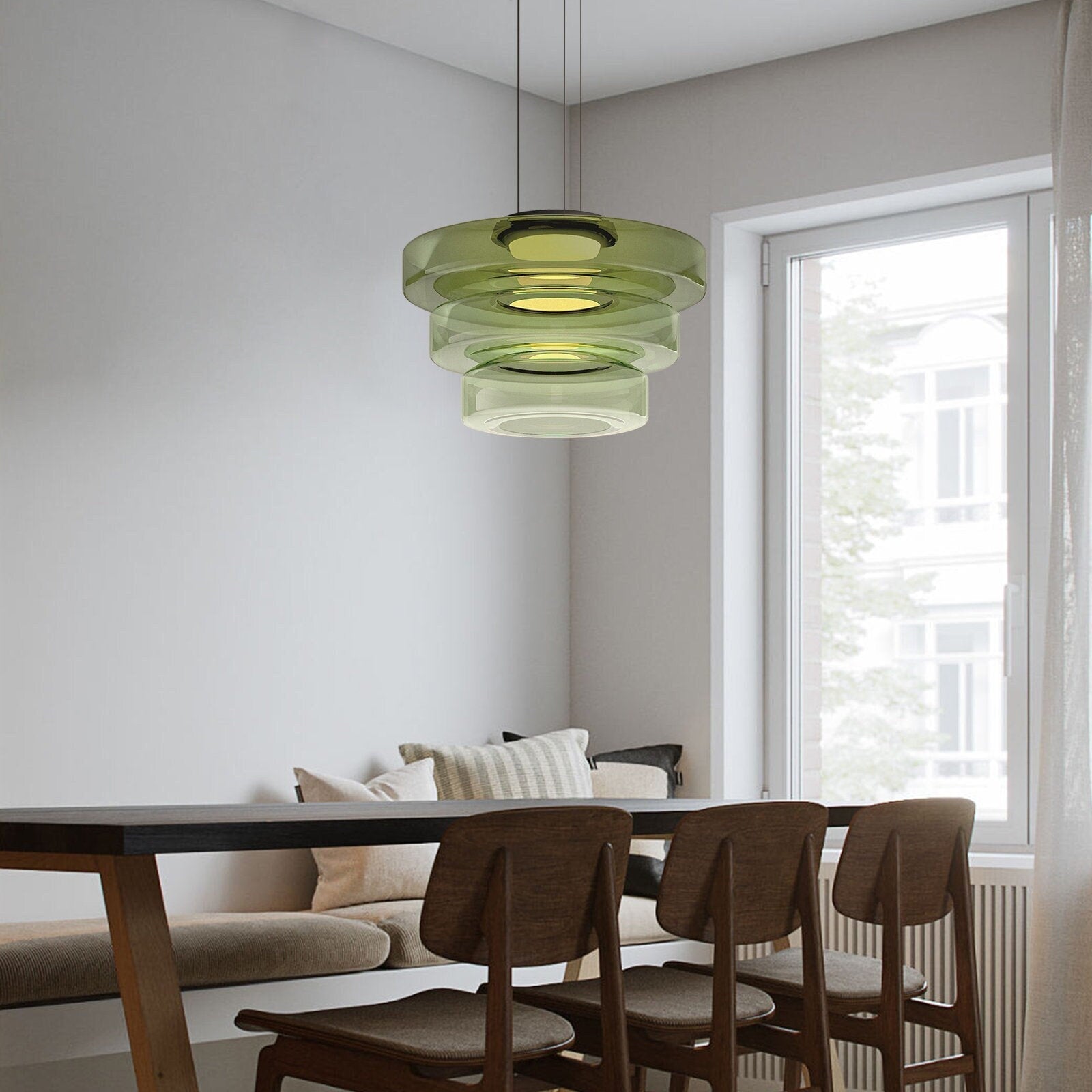 Green three-layer pendant above dining table