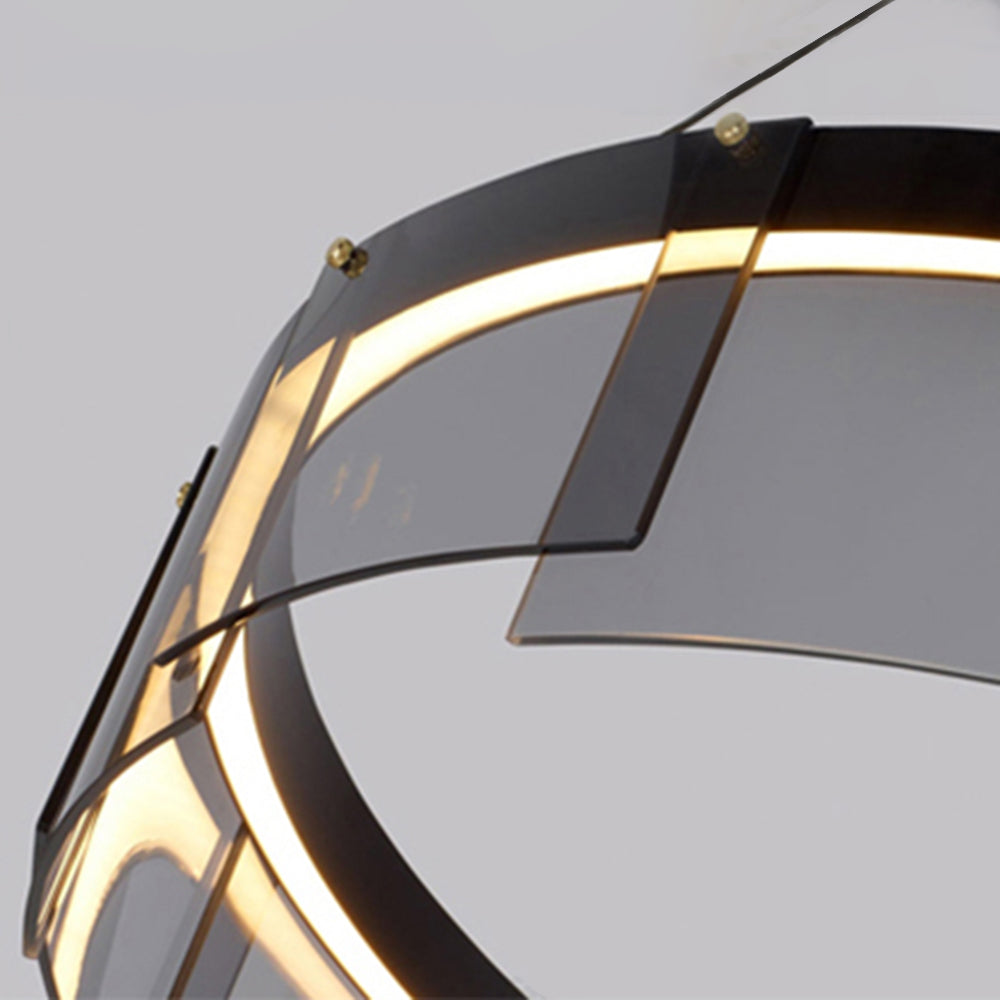 Lit close-up of the inner circle, overlapping rectangular panels, small fasteners and a suspension wire