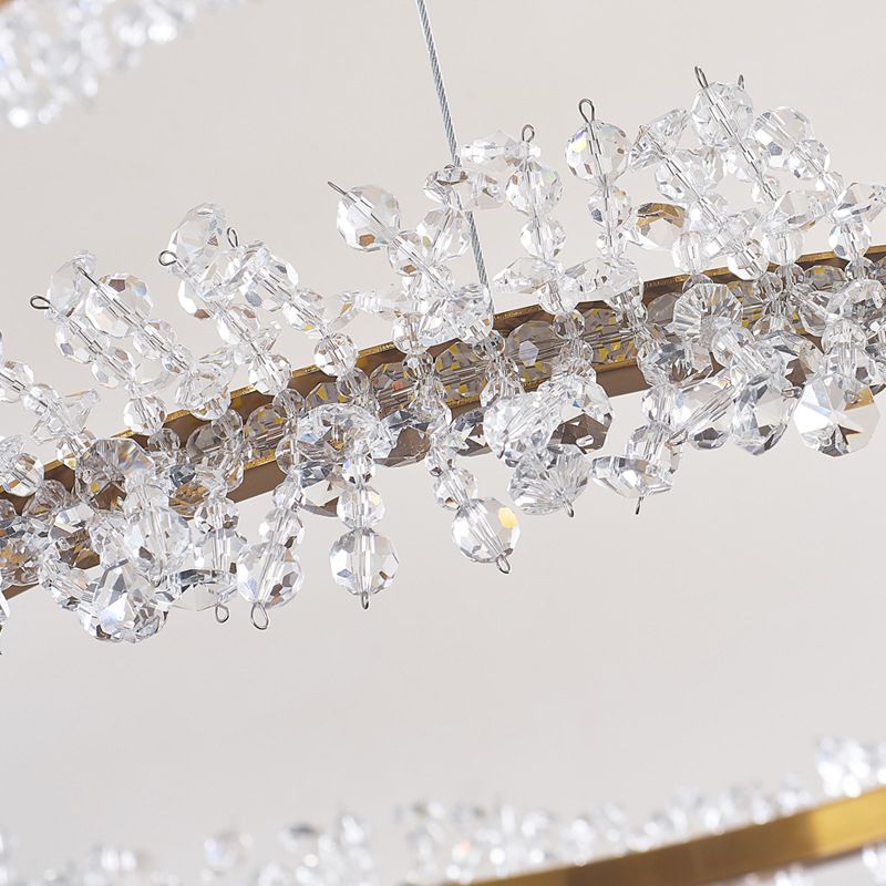 Close-up of transparent faceted flower decorations attached around a gold-tone Kristy ring beside a suspension wire.