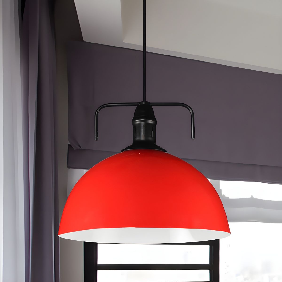 Red metal dome pendant against dark wall