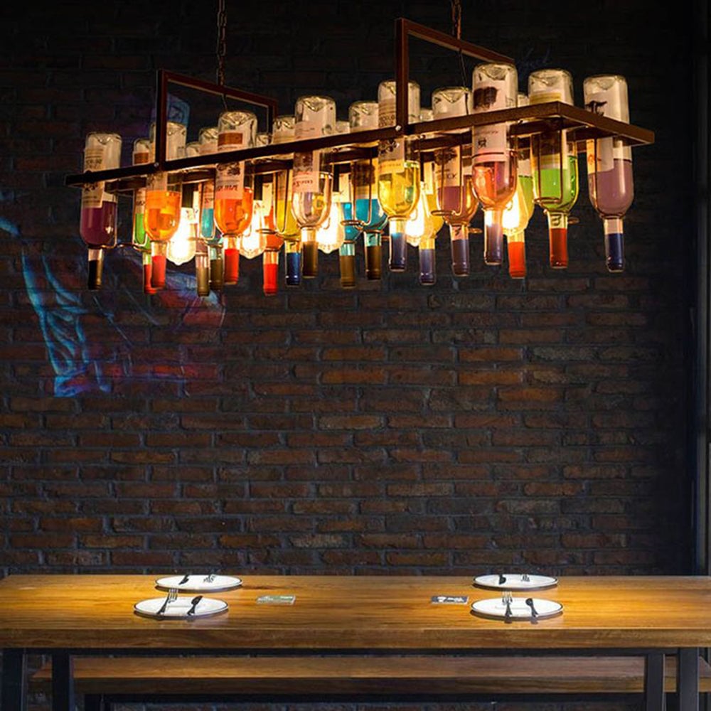 Long rust-tone bottle pendant glowing above a restaurant table.