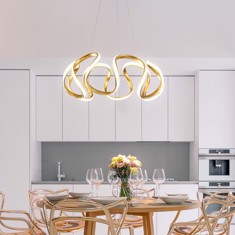 Golden five-head curved ribbon pendant over dining table