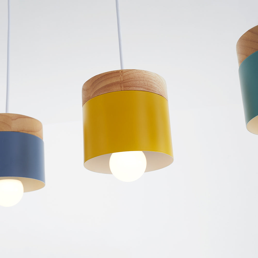 Close yellow cylinder pendant with wood-grain top and lit bulb, with partial gray and green heads