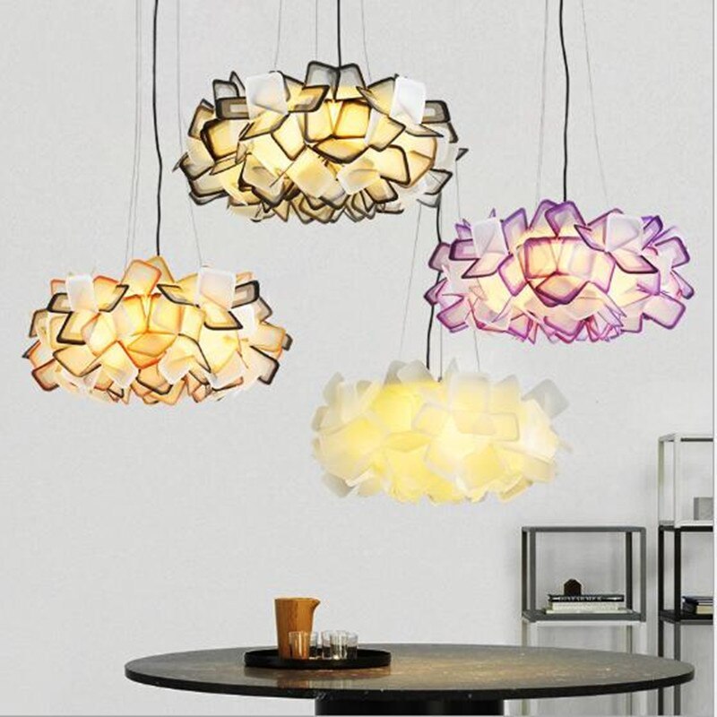 Separate Black, Orange, Purple and White Bella flower pendants above a round dark dining table with cups and shelving