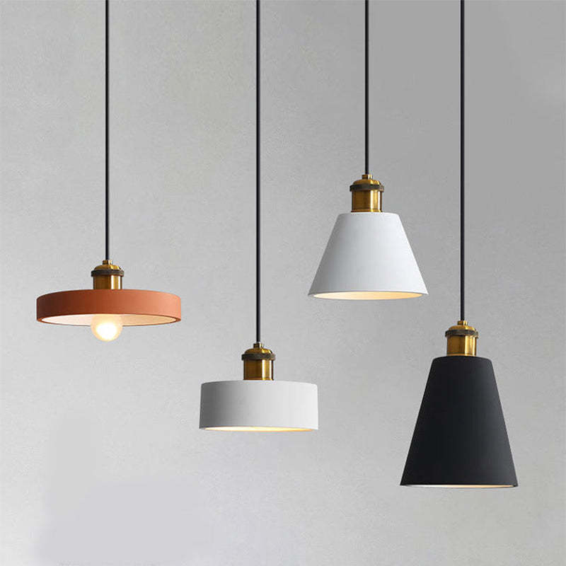 Four Morandi pendant shapes hanging at different heights against a grey wall.