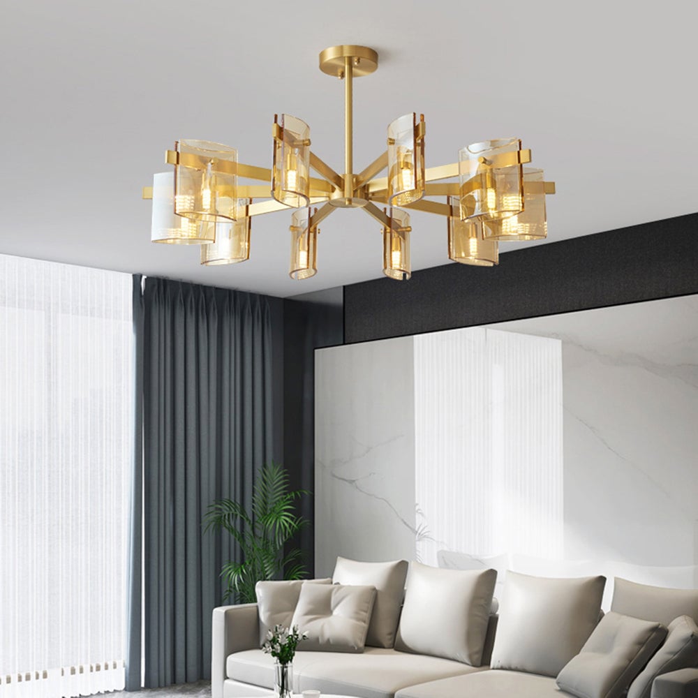 Gold 10-head pendant with amber-toned glass above a pale sofa, cushions, a tall plant and light wall panels