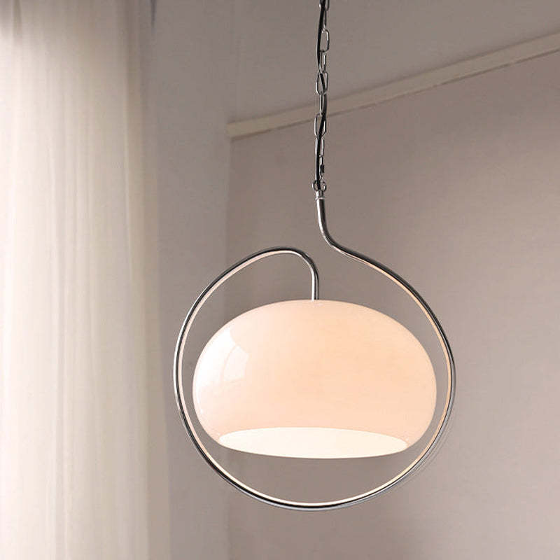 Hailie white glass pendant suspended beside a curtain.