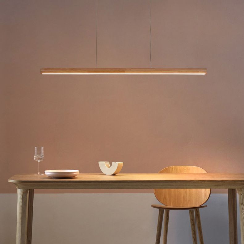 Illuminated wood bar pendant above a small dining table