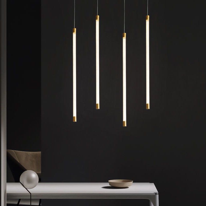 Edge vertical tube pendants at varied heights above a console