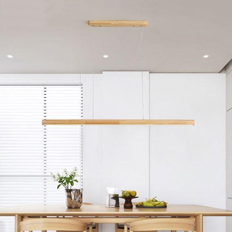 Long wood-tone pendant light over rectangular dining table
