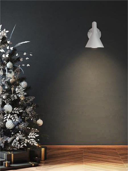 White Calix wall lamp illuminating a dark wall beside a decorated tree