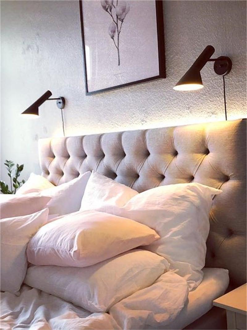 A pair of Calix wall lamps pictured above an upholstered headboard
