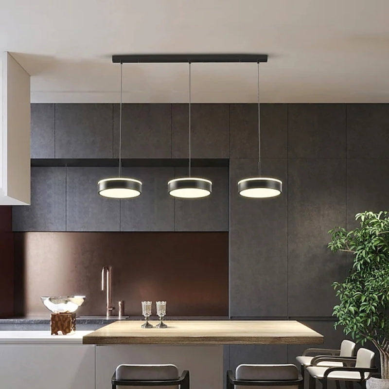 Black Raheel three-disc pendant above a kitchen island and stools.