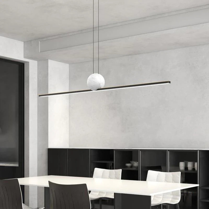 Black Edge bar pendant with a white sphere suspended above a dining table.