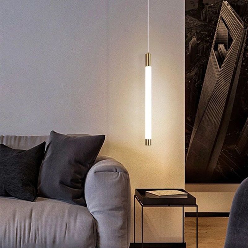 Single lit Edge tube pendant beside a dark sofa and small table