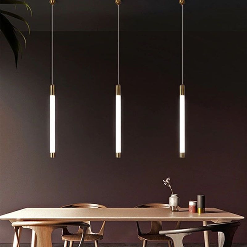 Edge pendant trio spaced above a dining table in a dark room