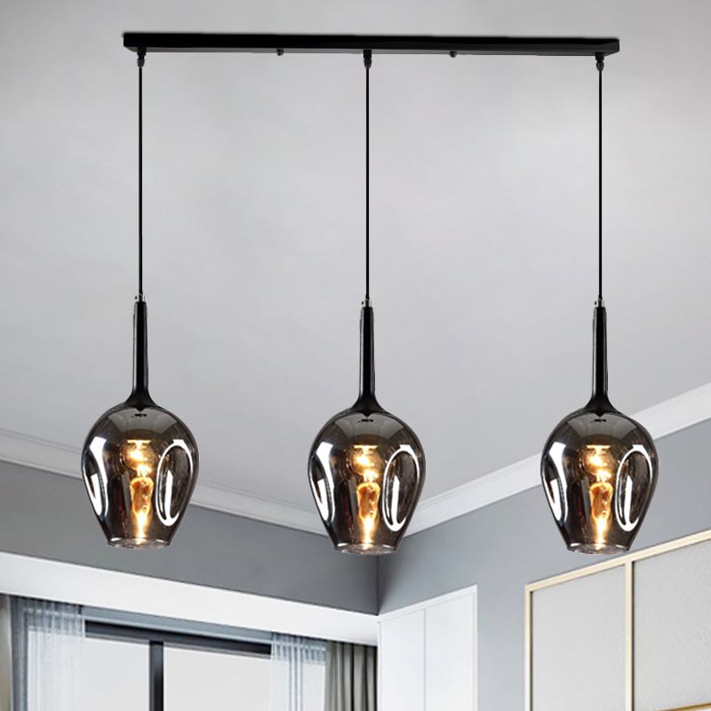 Hailie Smoke Gray glass pendant with three dark shades near windows
