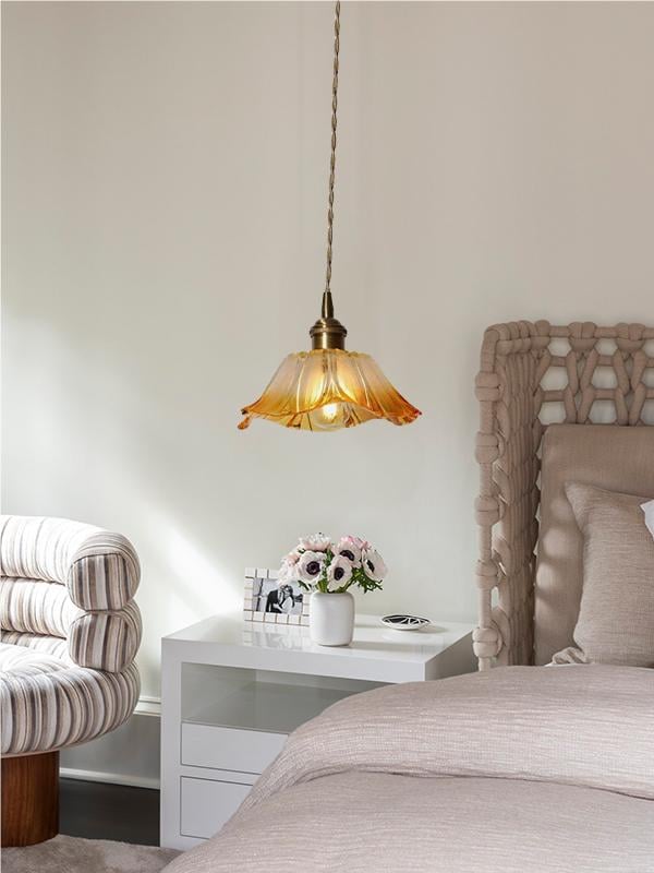 Compact yellow lotus glass pendant beside a bed