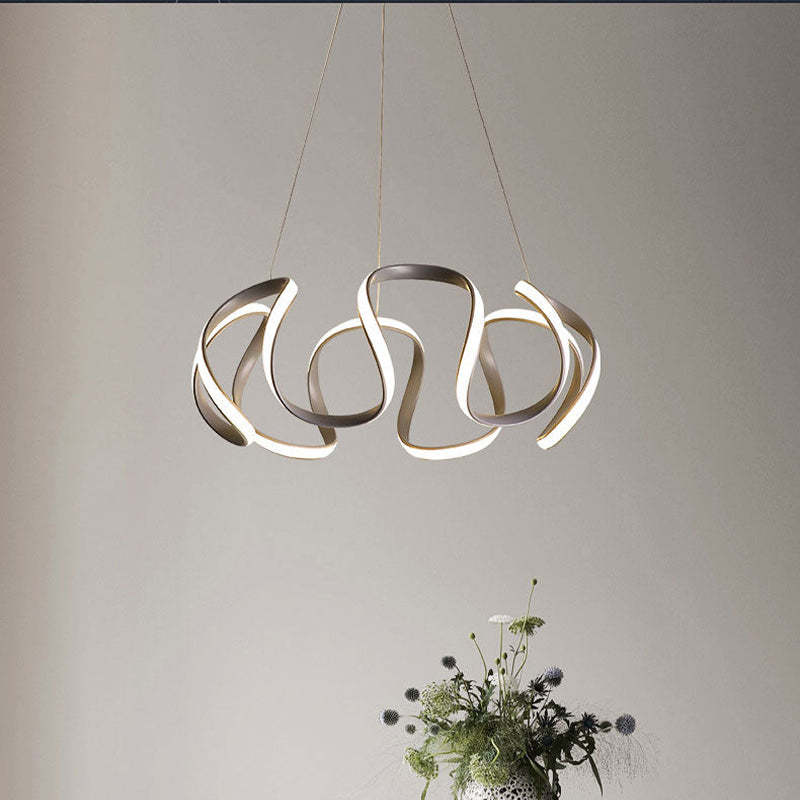 Gray illuminated curved-ribbon pendant above flowers
