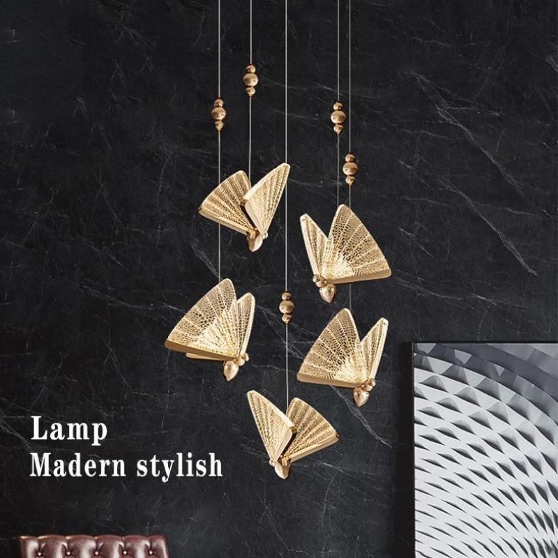 A cascading group of gold Kady butterfly pendants against dark stone