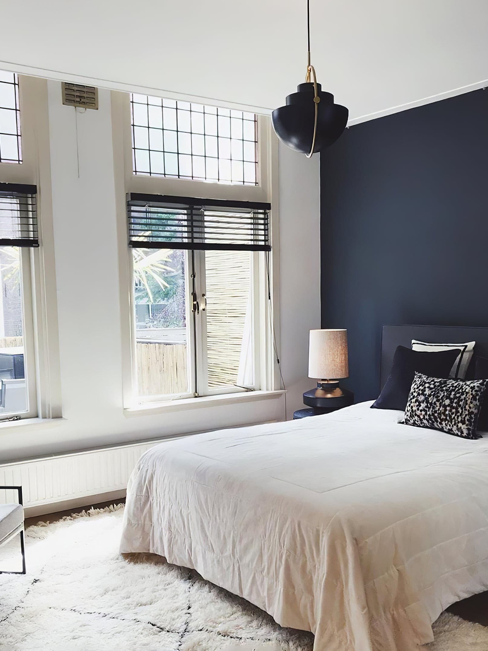 Black pendant with split shade halves in a bedroom