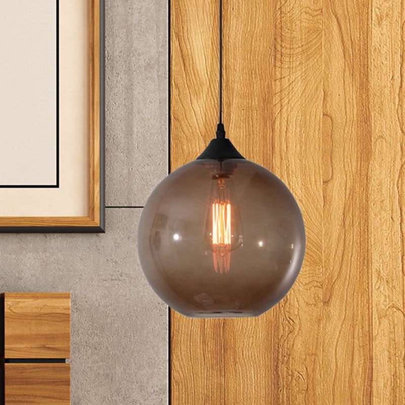 Coffee tinted glass globe pendant in wood-toned room