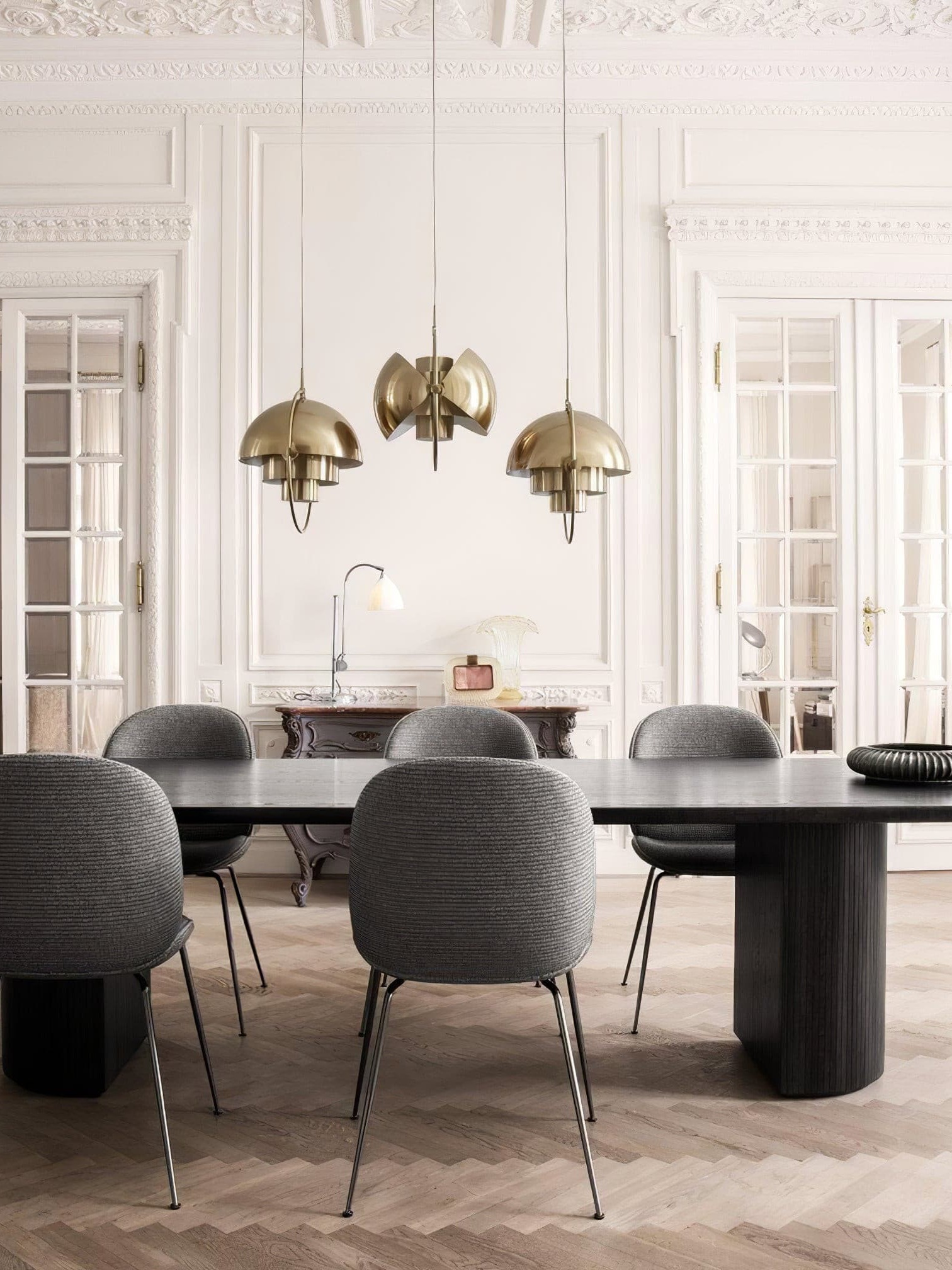 Copper-finish pendants in a paneled dining room