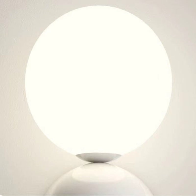 Close view of the illuminated Valentina glass globe above a white rounded fitting