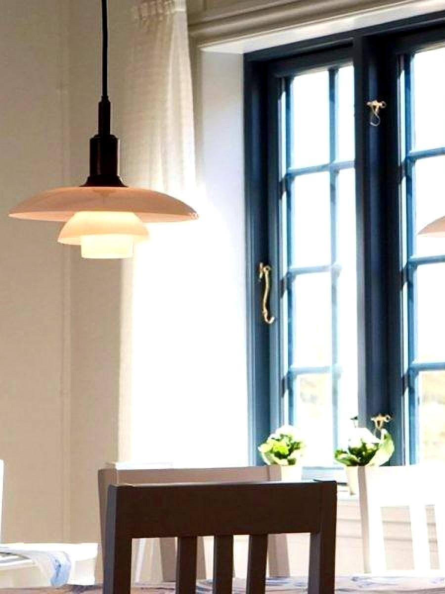Illuminated opal disc pendant beside a dining-room window