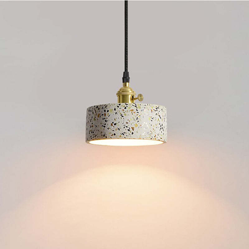Short speckled drum shade with a gold-tone holder, side knob and glowing lower opening