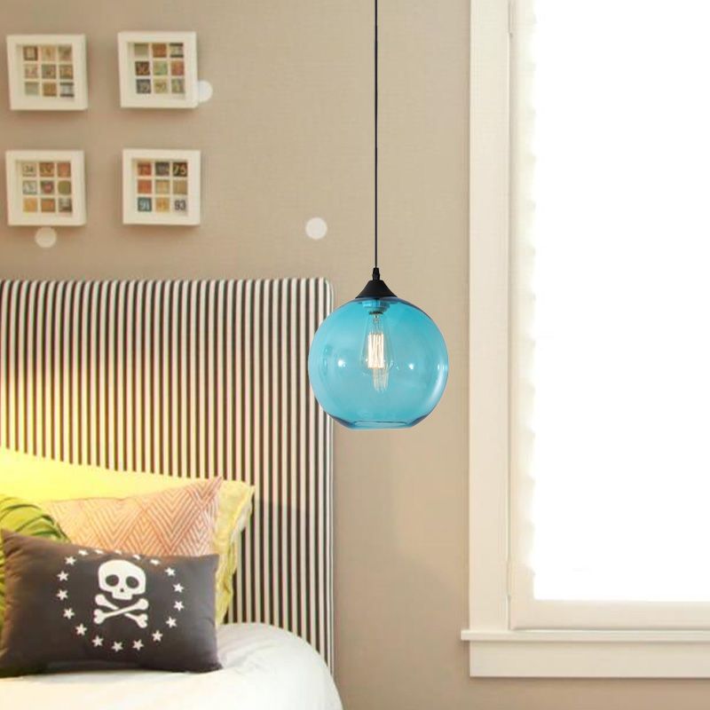 Sky Blue glass globe pendant beside a bed