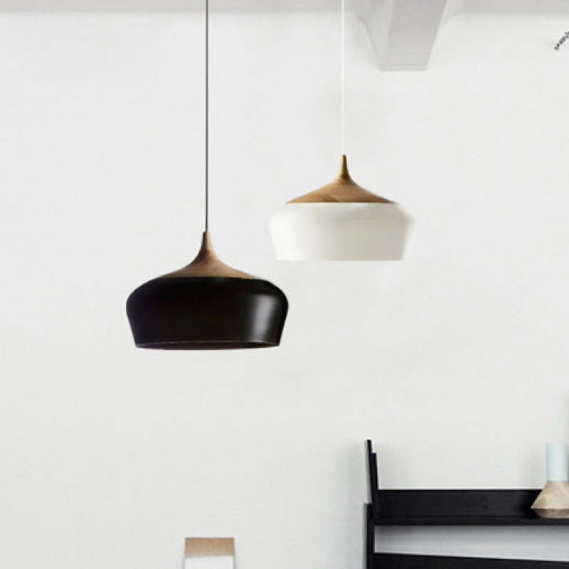Black and white Nazifa pendants near a dark chair against a pale wall.