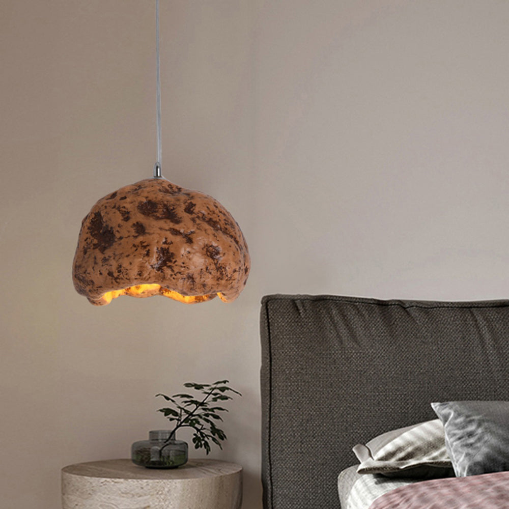 Wood-colour Byers irregular dome pendant light beside a bed and round side table