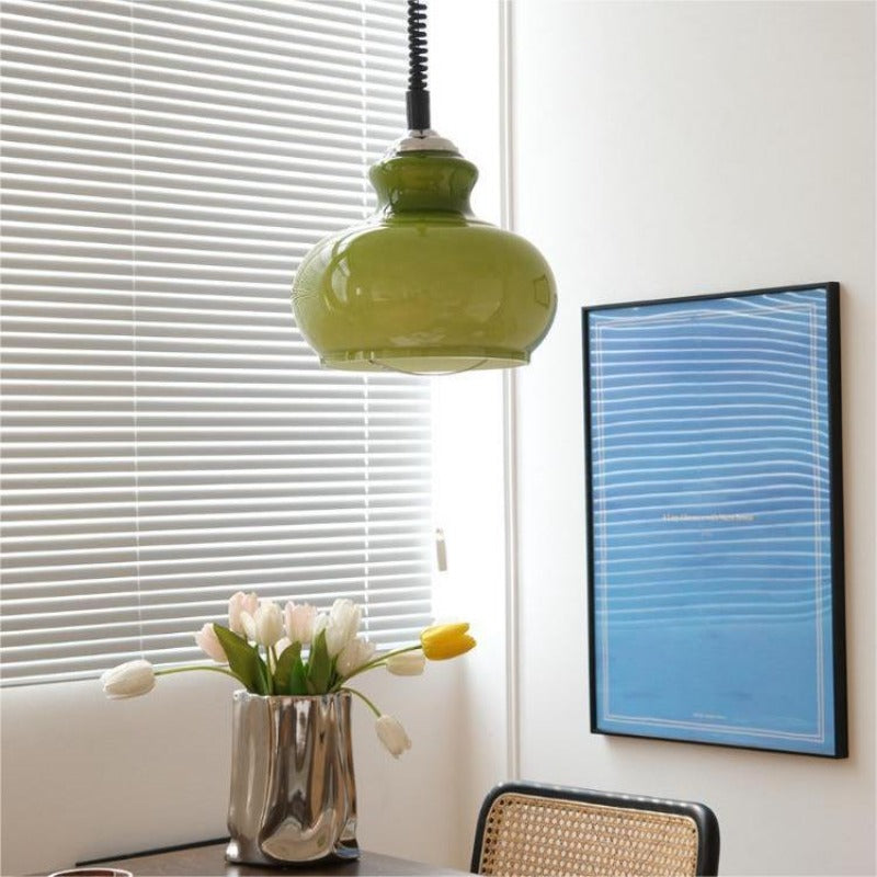 Green glass pendant above small table by window