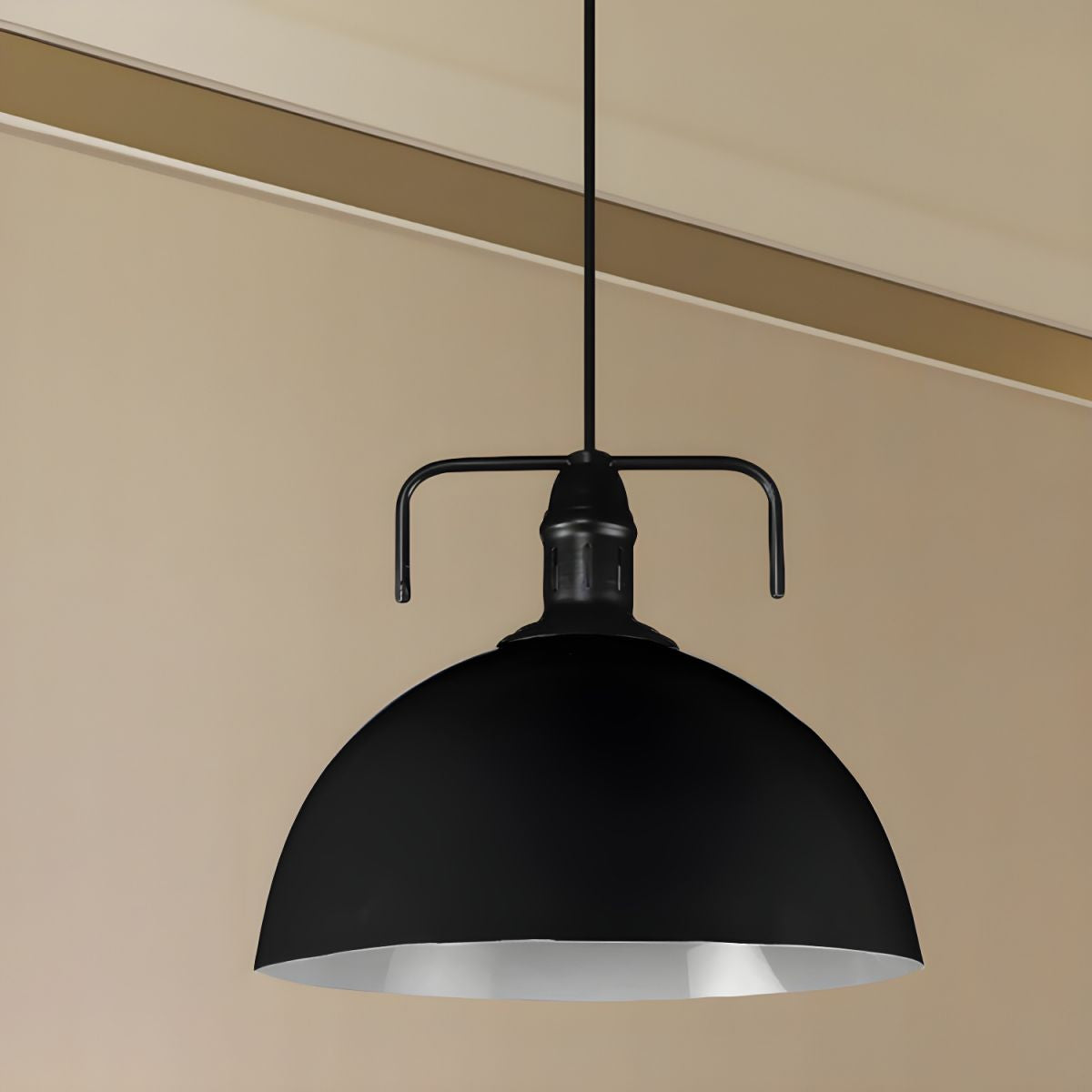 Black dome pendant against beige wall