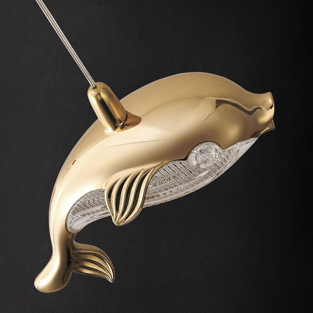 Close view of a gold-tone Jibril dolphin with a clear textured underside and detailed tail