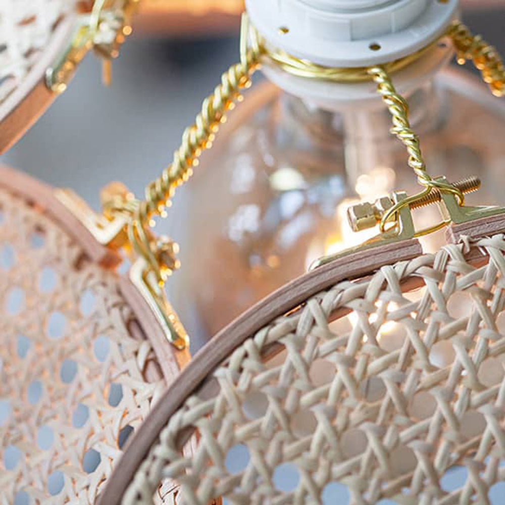 Macro of gold-tone twisted supports, bolts and clamps holding a woven panel with a brown rim