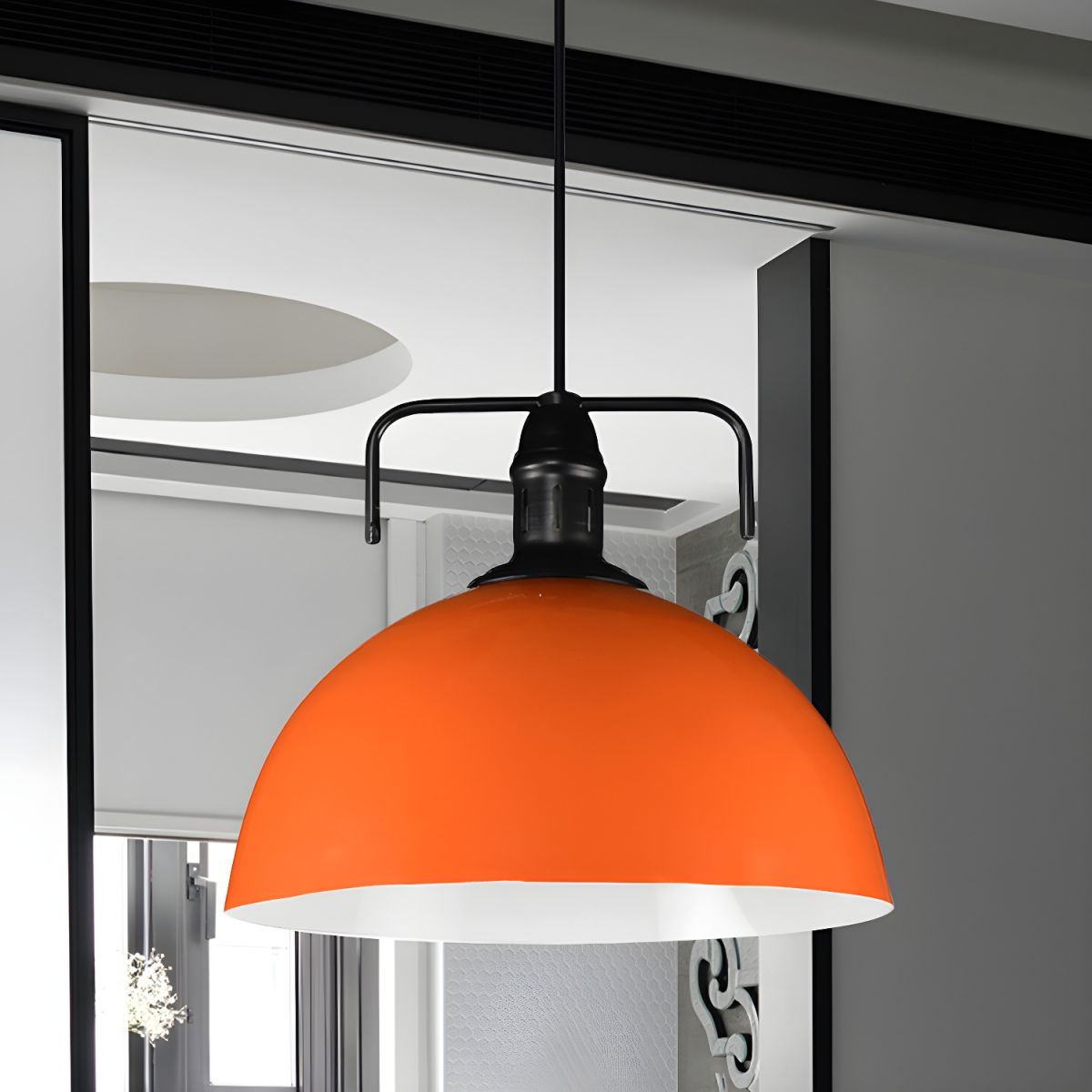 Orange metal dome pendant near window