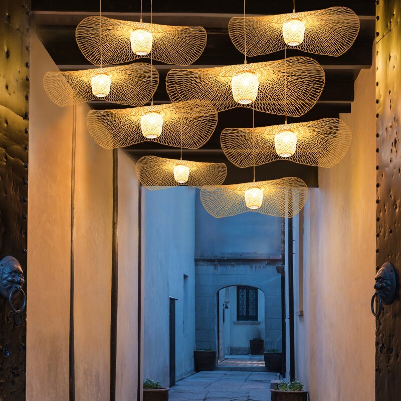Multiple wavy woven pendants illuminating a corridor beside large ornamental doors