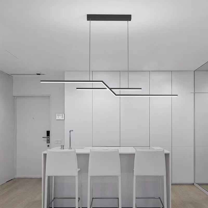 Black stepped pendant over a white kitchen counter with three stools