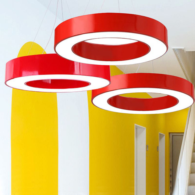 Three red ring pendant lights at staggered heights